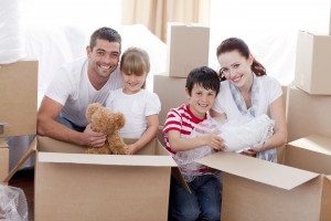 Happy young family Moving Home With Boxes Around